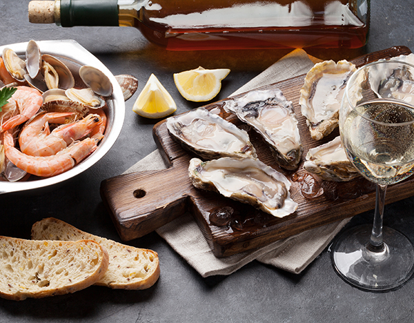 clams, shrimp, oysters, and white wine on stone table